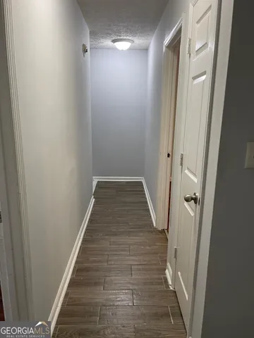 a view of a hallway with wooden floor and staircase