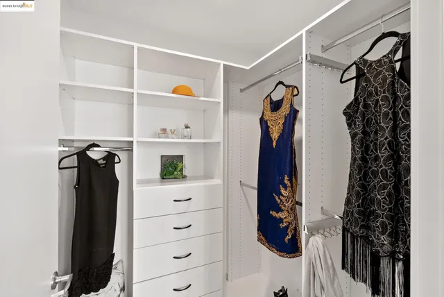 a view of walk in closet with clothes and shoes