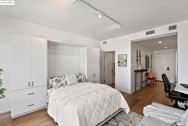 a bedroom with a bed and wooden floor