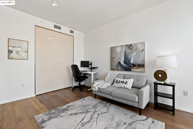 a view of a bedroom with a large bed and wooden floor