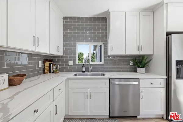 a kitchen with white cabinets and white appliances