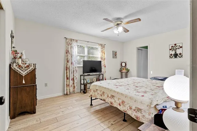 a bedroom with a bed and wooden floor