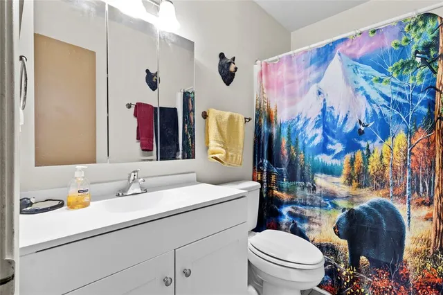 a bathroom with a sink vanity mirror and toilet