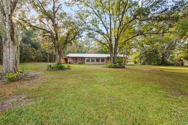 a view of a house with garden and trees