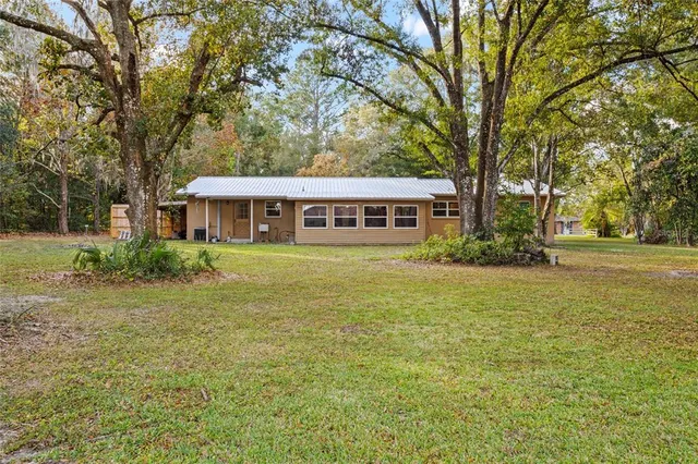a view of a house with garden and trees