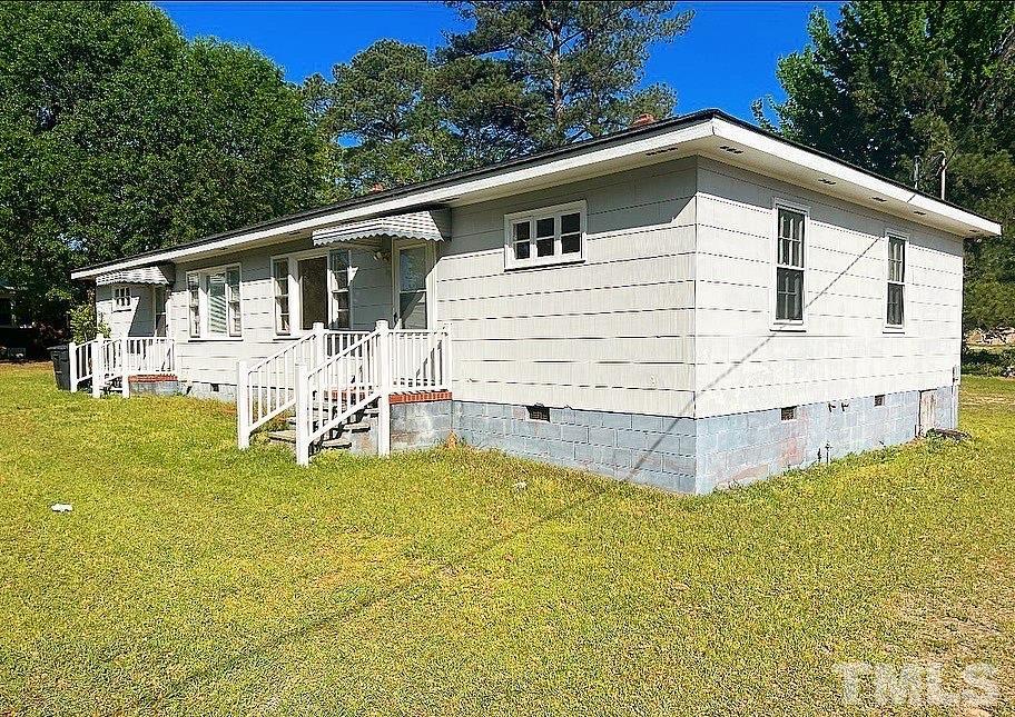 99 Susan Street, Unit 1 & 2 Clinton, NC 28328 - Photo 1 of 9 a white house that has garden in front of it