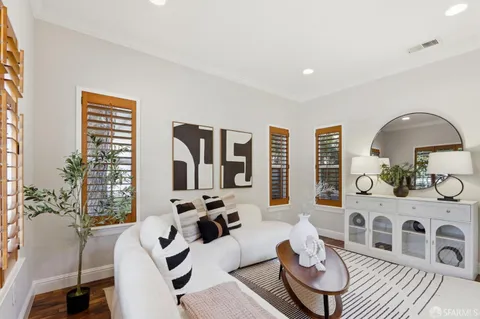 a living room with furniture a rug a lamp and a large window