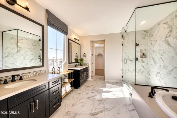a spacious bathroom with a tub sink shower and mirror