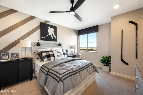 a bedroom with a bed a dresser and potted plants with the wooden floor