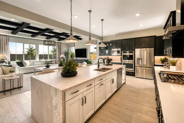 a kitchen with stainless steel appliances kitchen island a large counter top a stove a sink and a refrigerator