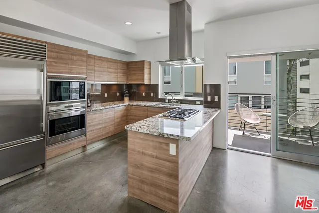 a kitchen with stainless steel appliances granite countertop a stove a sink and a refrigerator