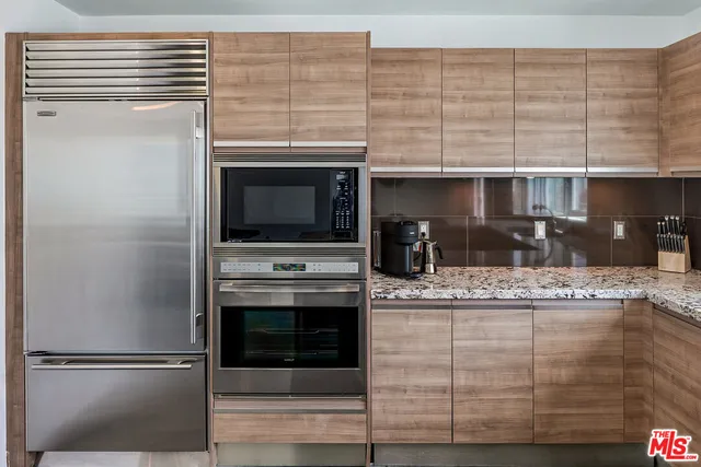 a kitchen with kitchen island stainless steel appliances and cabinets