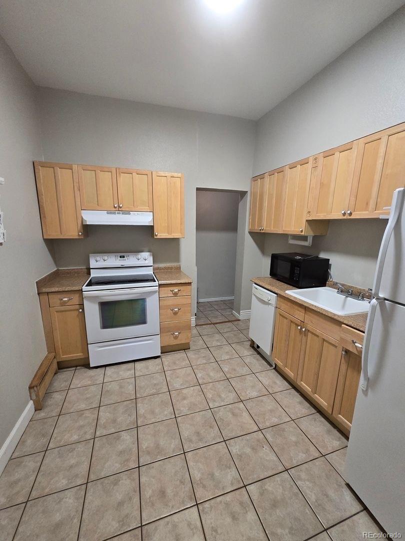 3127 West 28th Avenue, Unit 7 Denver, CO 80211 - Photo 3 of 11 a kitchen with a stove a sink and a microwave