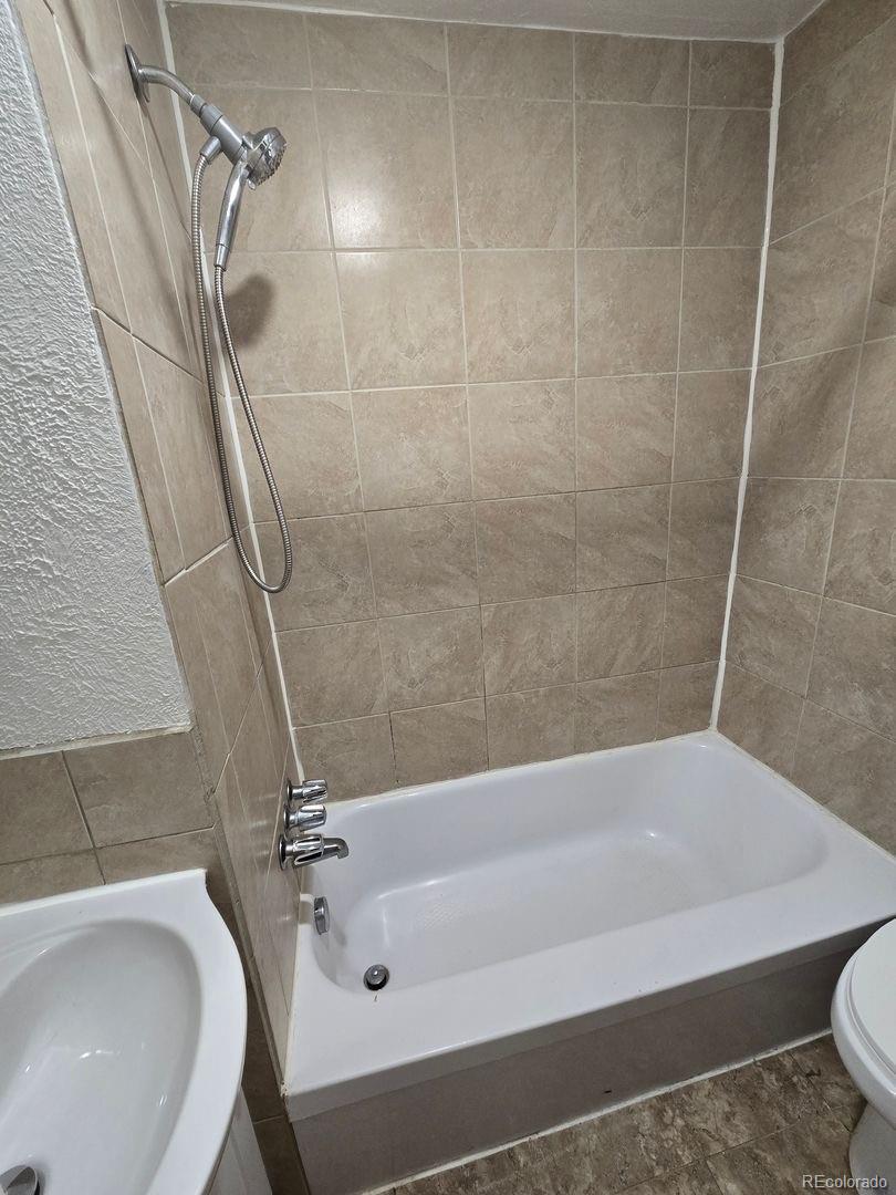 3127 West 28th Avenue, Unit 7 Denver, CO 80211 - Photo 7 of 11 a bathroom with a tub a sink and dryer