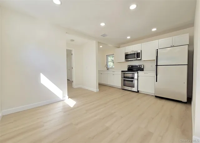 a view of kitchen with stainless steel appliances a refrigerator and a stove top oven