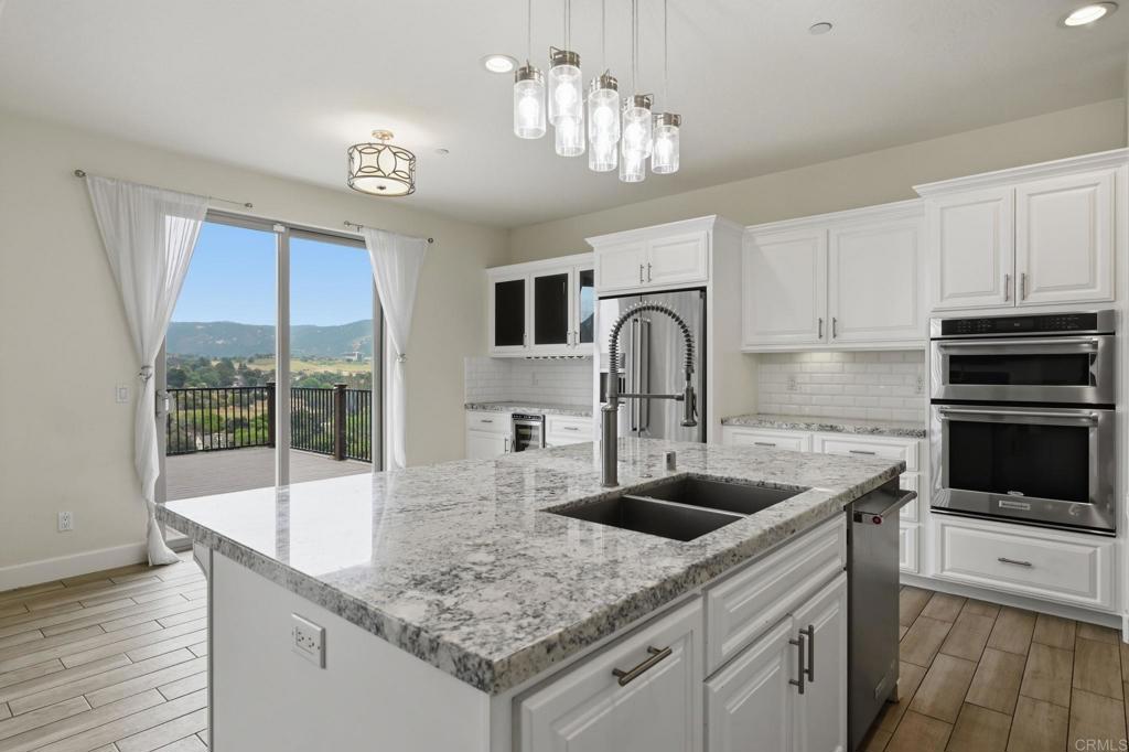 1910 Harbison Canyon Road El Cajon, CA 92019 - Photo 11 of 71 a kitchen with kitchen island granite countertop a sink a counter top space cabinets and stainless steel appliances