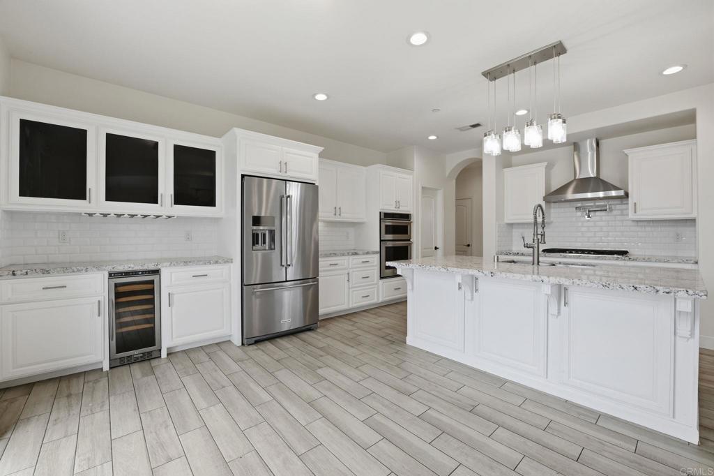 1910 Harbison Canyon Road El Cajon, CA 92019 - Photo 12 of 71 a kitchen with stainless steel appliances kitchen island granite countertop a refrigerator and a stove top oven