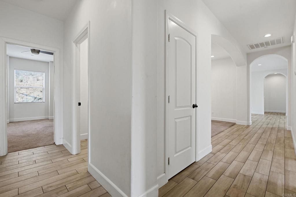 1910 Harbison Canyon Road El Cajon, CA 92019 - Photo 30 of 71 a view of a hallway with wooden floor and a bathroom
