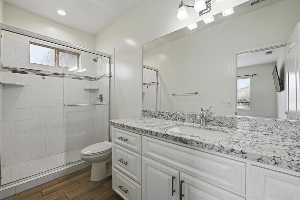 1910 Harbison Canyon Road El Cajon, CA 92019 - Photo 34 of 71 a bathroom with a granite countertop sink a toilet and shower