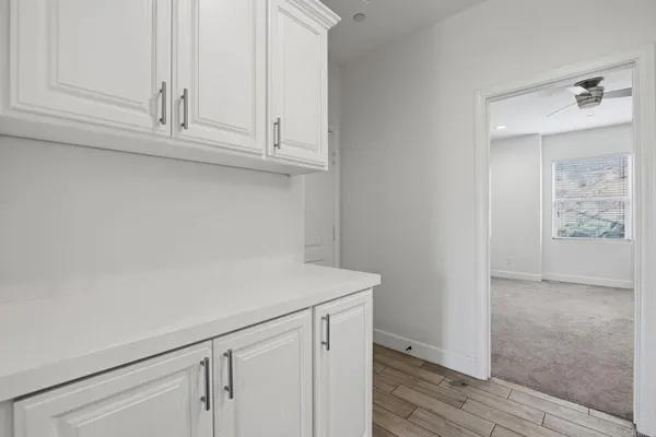 a kitchen with white cabinets a stove and wooden floor
