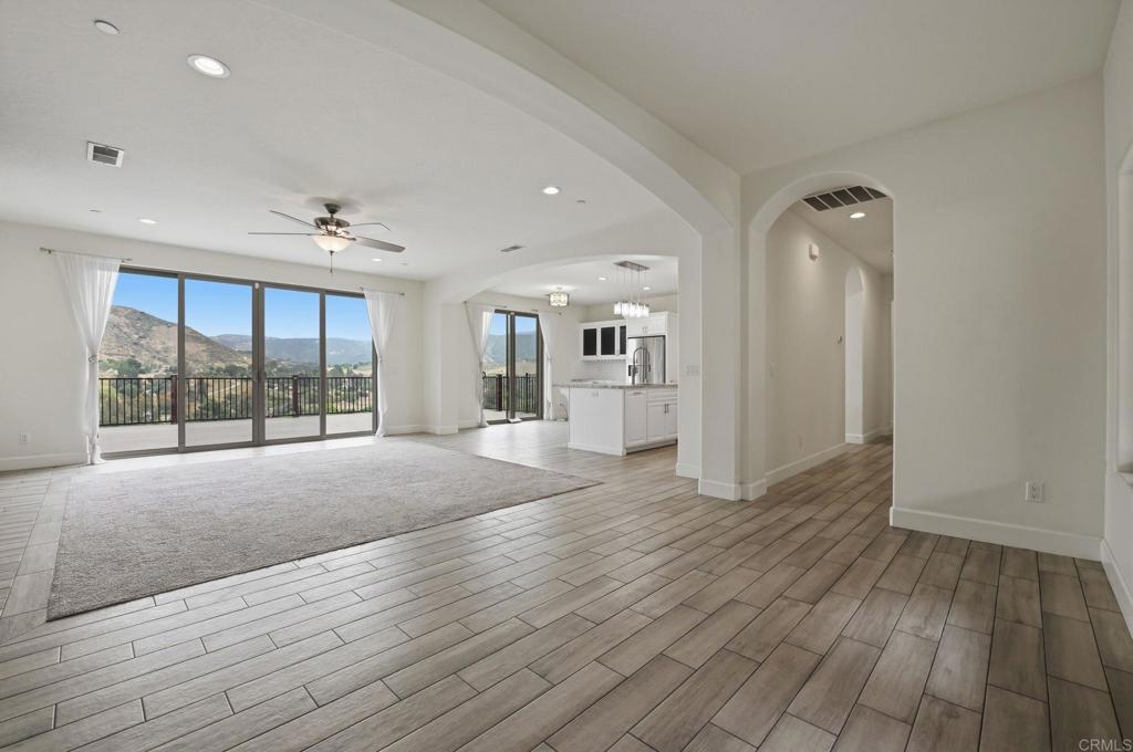 1910 Harbison Canyon Road El Cajon, CA 92019 - Photo 6 of 71 a view of an empty room with wooden floor and a window