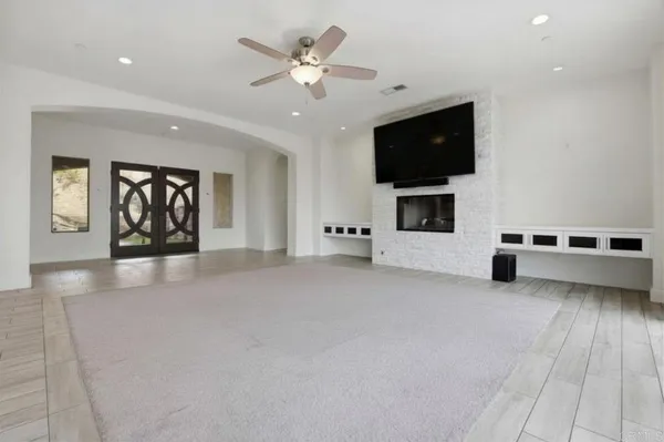 a view of a livingroom with furniture a ceiling fan and window