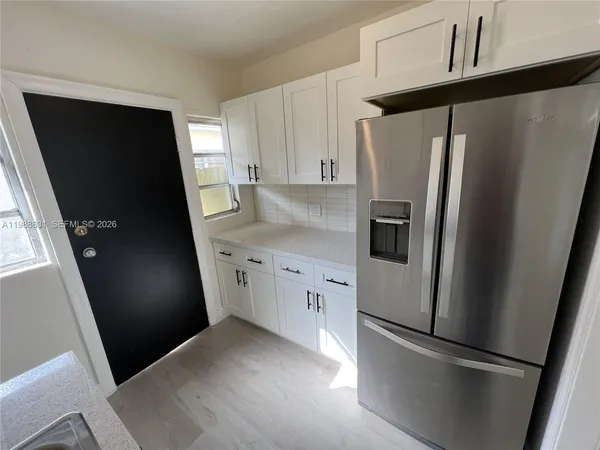a kitchen with a refrigerator a sink and cabinets