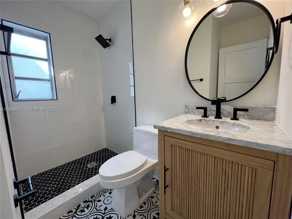a bathroom with a sink a toilet and a mirror