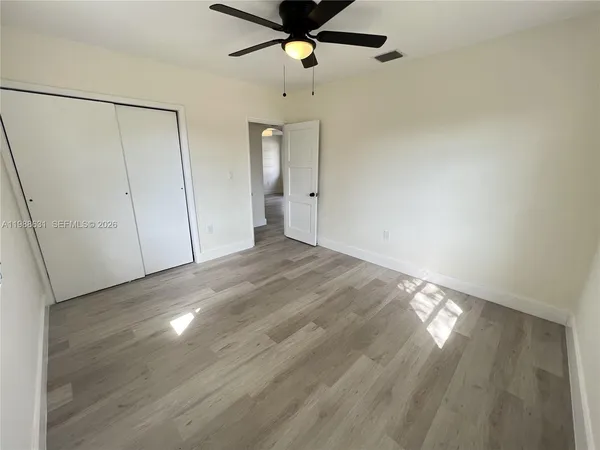 a view of empty room with wooden floor