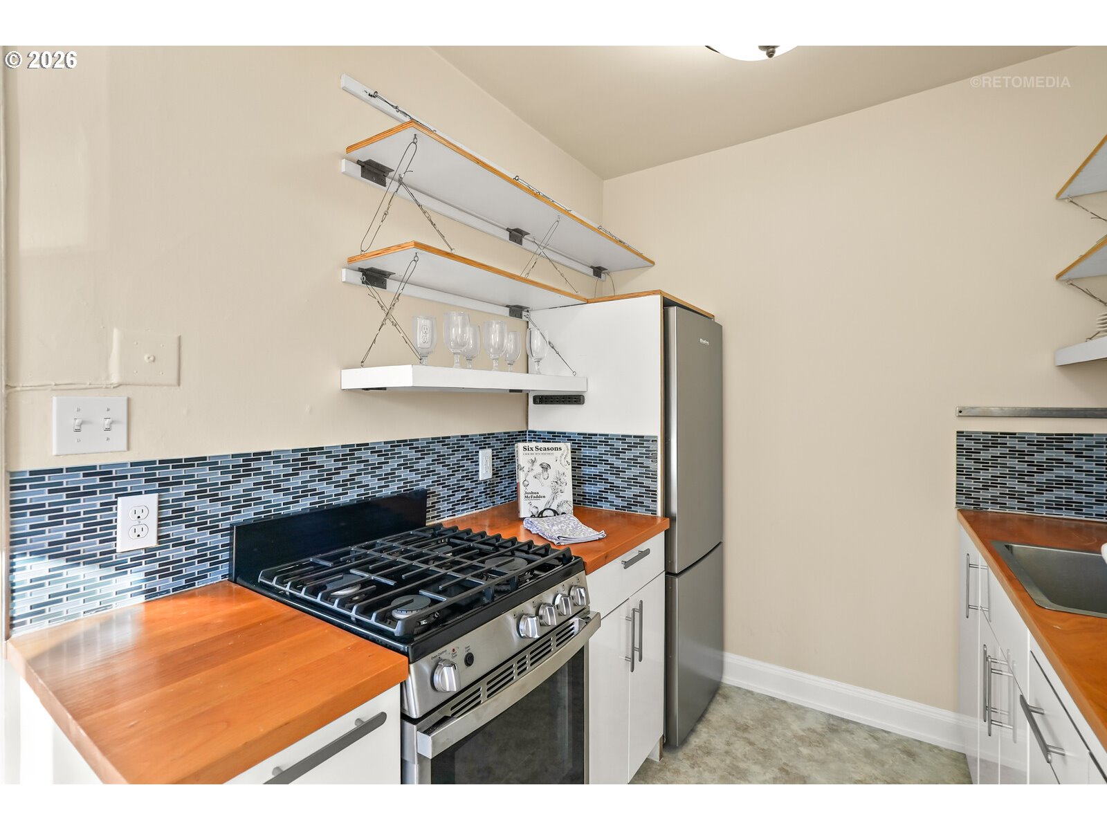 709 Southwest 16th Avenue, Unit 308 Portland, OR 97205 - Photo 15 of 22 a kitchen with blue cabinets and a stove top oven