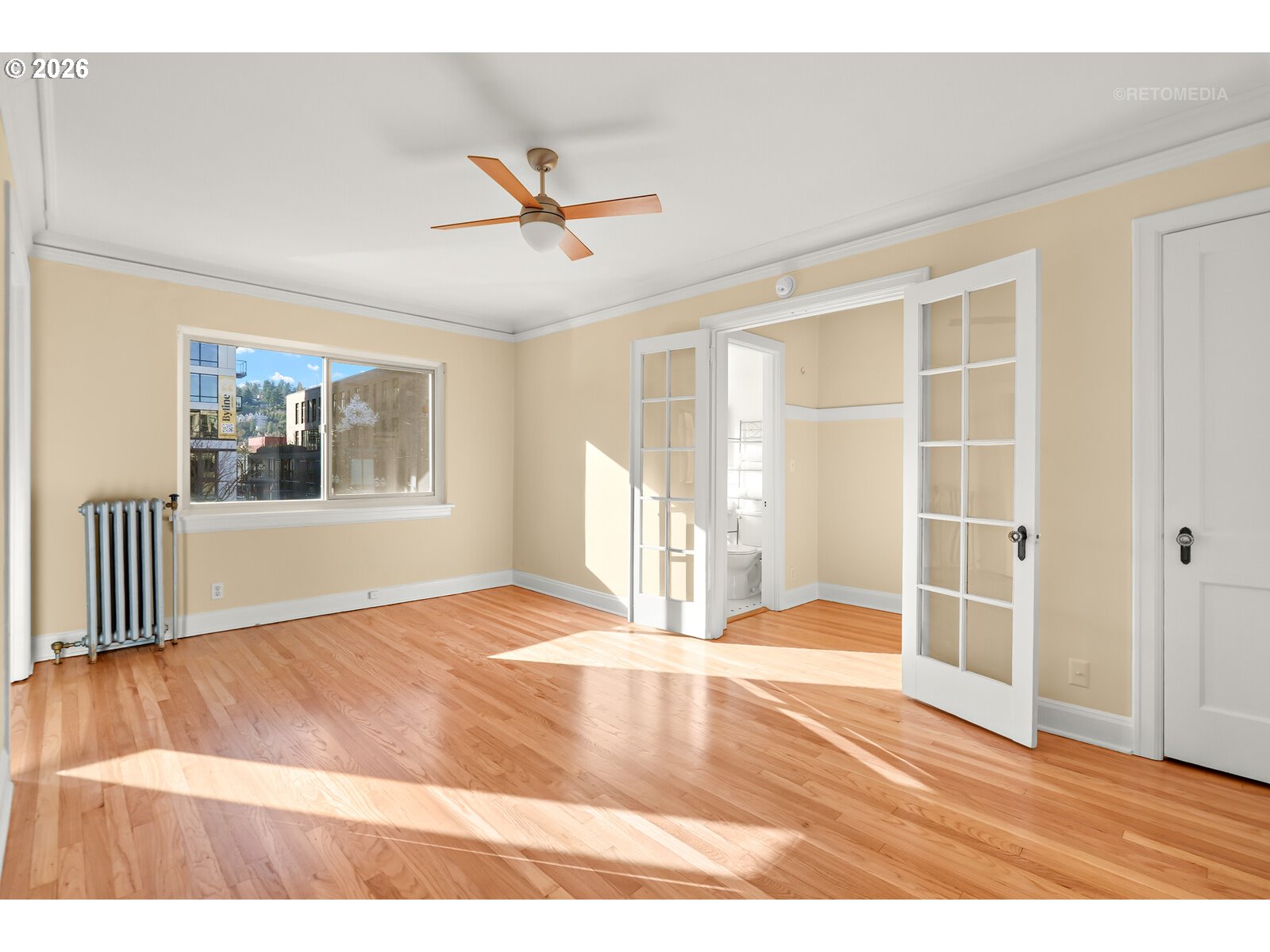 709 Southwest 16th Avenue, Unit 308 Portland, OR 97205 - Photo 7 of 22 a view of an empty room with wooden floor and a window