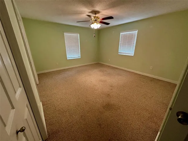 a view of an empty room and a ceiling fan