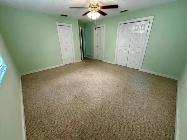 a view of an empty room with a ceiling fan