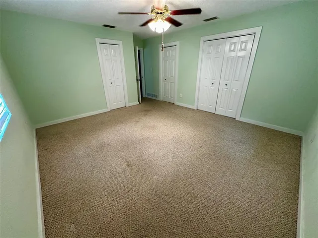 a view of an empty room with a ceiling fan