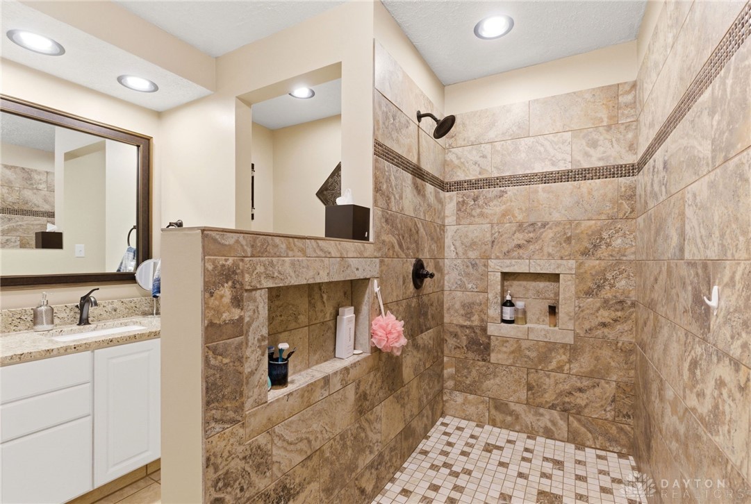 8916 Paragon Road Dayton, OH 45458 - Photo 22 of 33 This primary bathroom features a spacious shower with exquisite tile work and a sleek vanity.