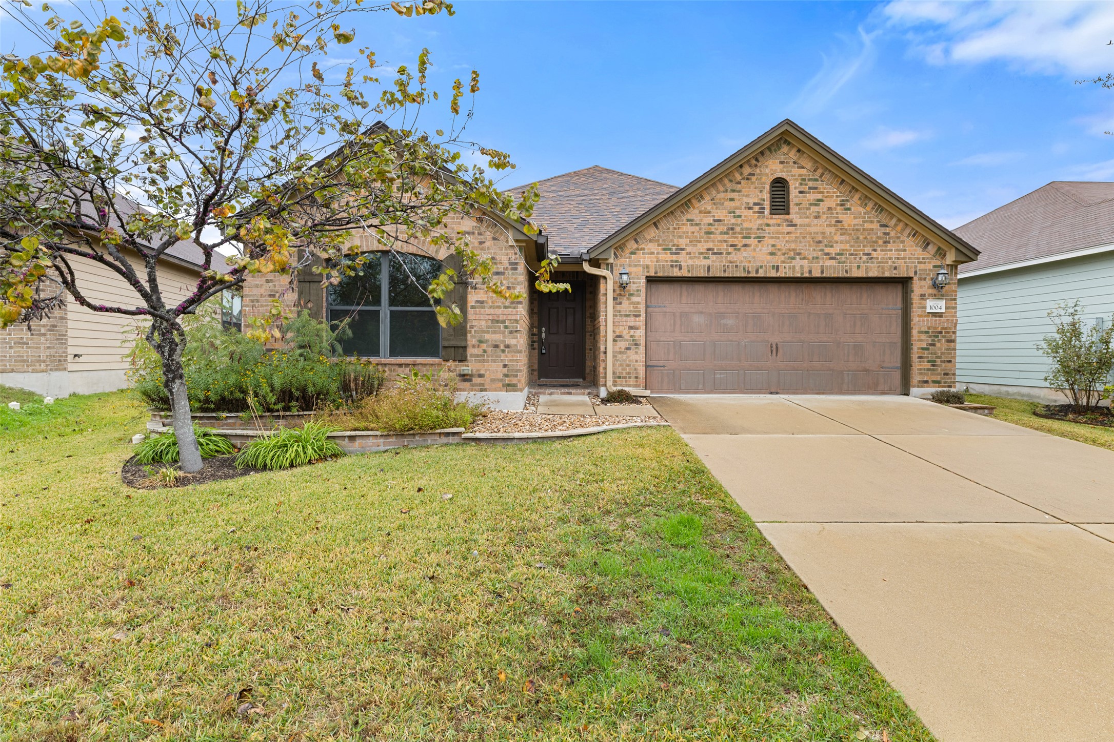 1004 Bethel Way Pflugerville, TX 78660 - Photo 1 of 1 Single story home featuring brick siding, concrete driveway, a garage, and a front yard
