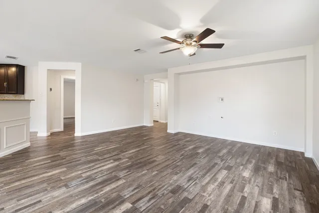 a view of a livingroom with wooden floor and a ceiling fan