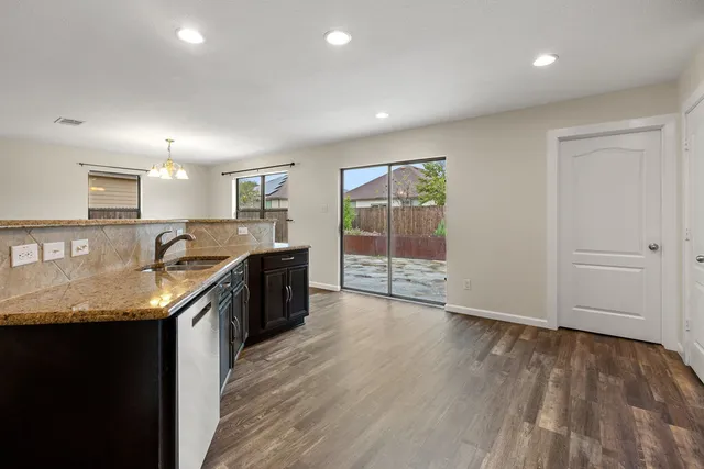 a kitchen with stainless steel appliances granite countertop wooden cabinets and a stove top oven