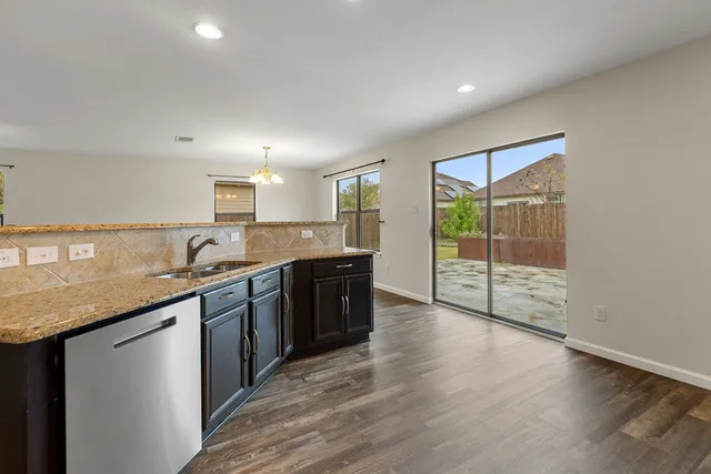 a kitchen with granite countertop a sink and cabinets