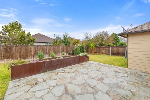a view of a backyard with wooden fence
