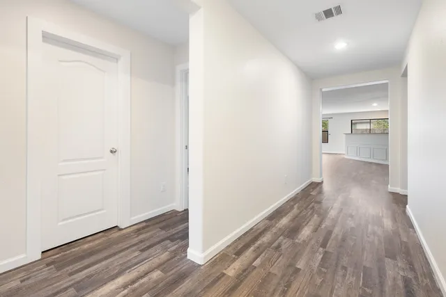 a view of a hallway with wooden floor