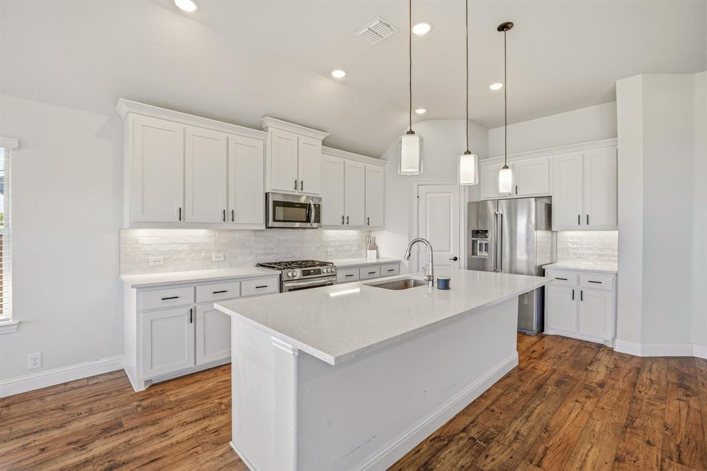 800 Jaguar Ridge Godley, TX 76044 - Photo 12 of 23 a kitchen with stainless steel appliances kitchen island a sink a stove a refrigerator and white cabinets