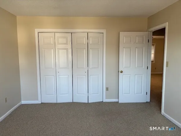 a view of an empty room with closet area