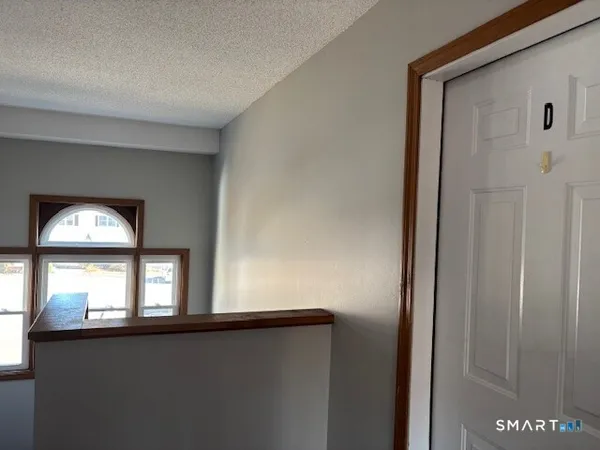 a view of a hallway with wooden floors and a window