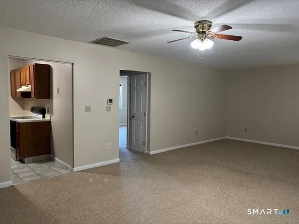 an empty room with closet and a chandelier fan