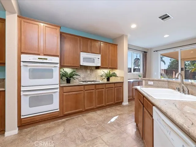 a kitchen with granite countertop cabinets stainless steel appliances and a counter space