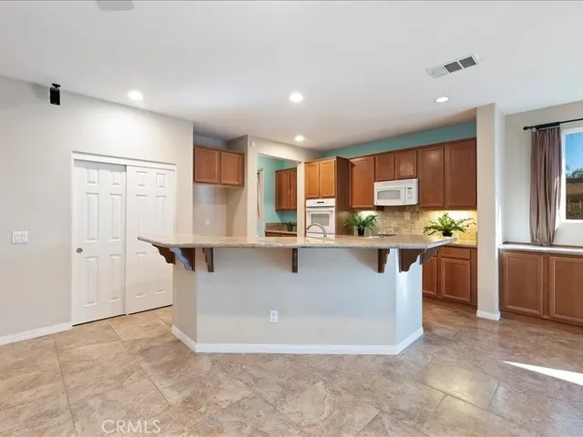 a kitchen with stainless steel appliances granite countertop a stove a sink and a microwave