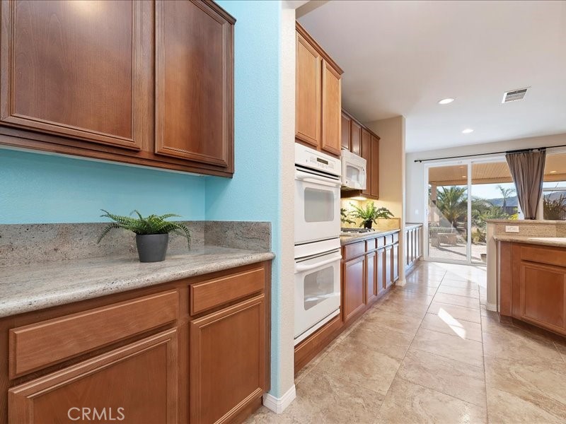 19069 Eldorado Road Perris, CA 92570 - Photo 24 of 49 a kitchen with stainless steel appliances granite countertop a stove a sink and a microwave