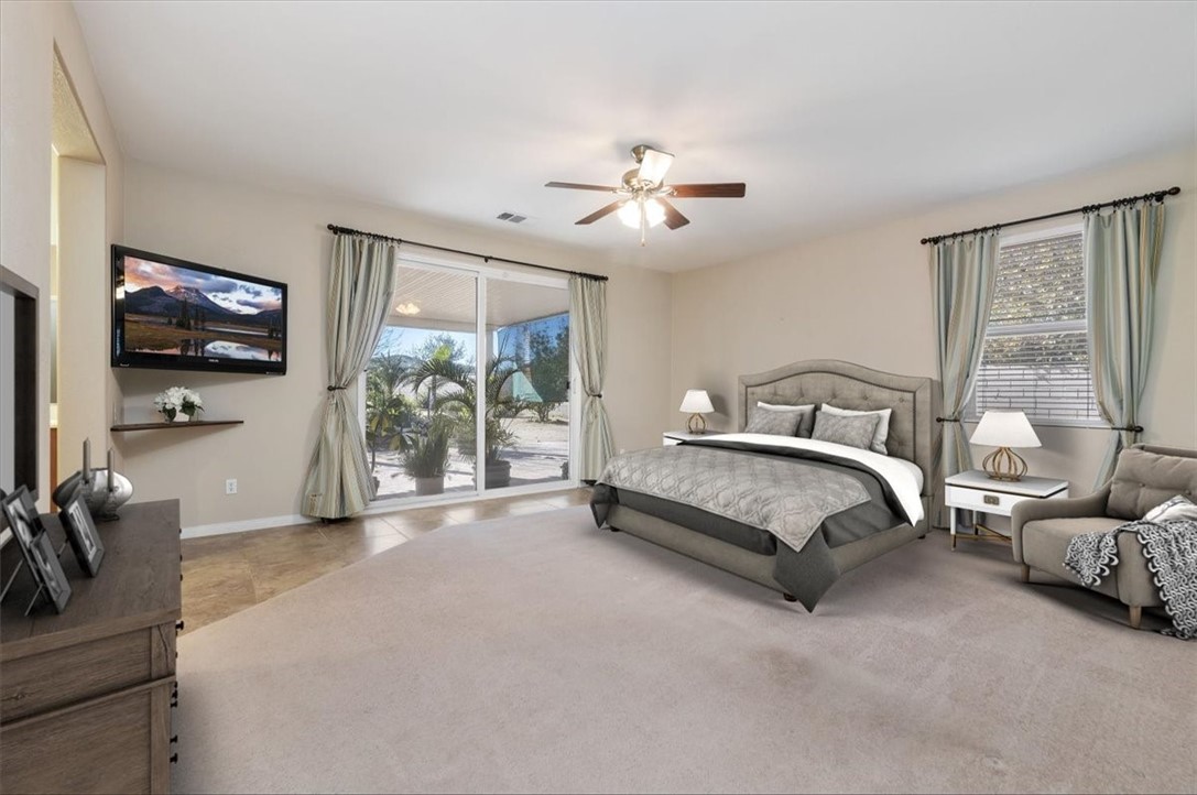19069 Eldorado Road Perris, CA 92570 - Photo 29 of 49 a spacious bedroom with a bed and a flat tv screen on dresser