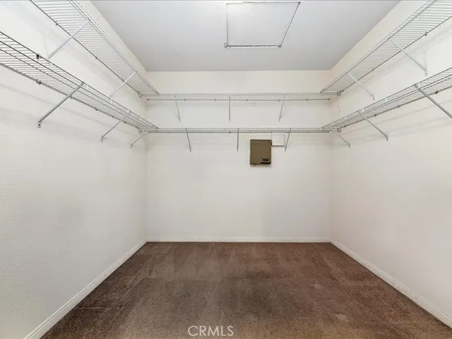 an empty room with ceiling fan and windows